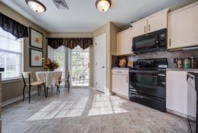 Mount Joy townhouse for rent - A kitchen with a table and chairs in front of a window at The Crest at Elm Tree, Mount Joy Pennsylvania
