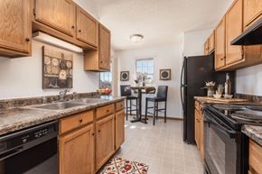 Brookfield apartment for rent - a kitchen with wooden cabinets and a black refrigerator