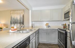 Naperville apartment for rent - A kitchen with black appliances and white cabinets.