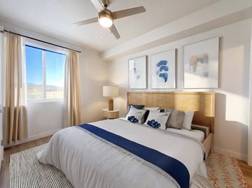 Park City apartment for rent - A bedroom with a large bed and a ceiling fan.