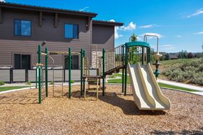 Park City apartment for rent - A playground with a slide, swings, and a climbing frame.