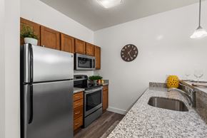 Salt Lake City apartment for rent - A kitchen with a refrigerator, microwave, and sink.