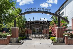 Salt Lake City apartment for rent - Property entrance with arched metal signage at Liberty Gateway Apartments, Utah, 84101