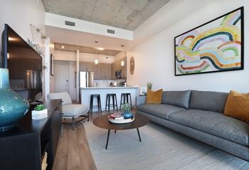 Open concept living room with kitchen and colorful artwork