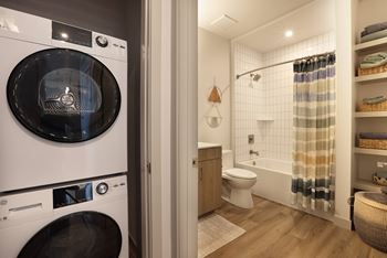 Bathroom with stacked washer dryer and open shelving