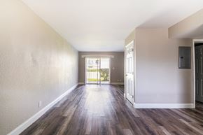 Daytona Beach apartment for rent - an empty living room with wood flooring and a door to a balconyat Palm Cove Apartments, Daytona Beach Florida