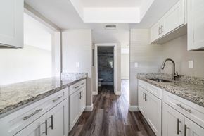 Daytona Beach apartment for rent - a kitchen with white cabinets and marble counter tops at Palm Cove Apartments, Daytona Beach, FL