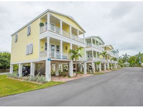Marathon apartment for rent - A yellow building with a balcony is on the corner of a street.