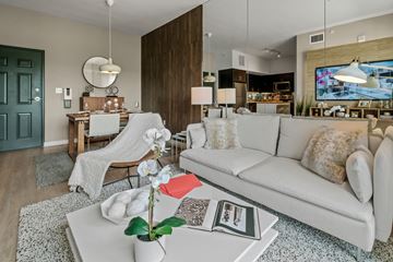 Princeton apartment for rent - A living room with a white couch and a coffee table with a vase of flowers on it.