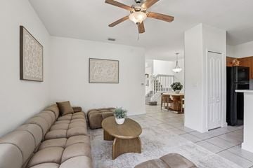 Homestead townhouse for rent - A living room with a brown couch and a ceiling fan.