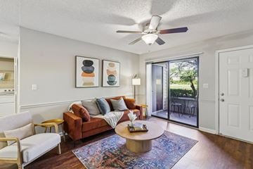 Daytona Beach apartment for rent - A living room with a brown couch and a ceiling fan.