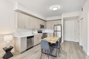 Miami apartment for rent - A kitchen with a table and chairs in the middle of the room.