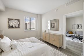 Miami apartment for rent - A bedroom with a large bed and a wooden cabinet.