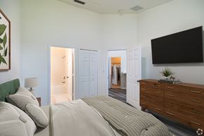 Homestead apartment for rent - A bedroom with a large bed and a flat screen TV mounted on the wall.