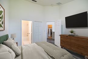 Homestead townhouse for rent - A bedroom with a large bed and a flat screen TV mounted on the wall.