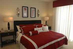 Homestead townhouse for rent - a bedroom with a bed with red comforter and pillows