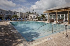 Key Largo townhouse for rent - A pool surrounded by a brick patio and a wooden pavilion.