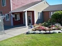 Tacoma apartment for rent - A house with a red door and a flower bed in front.