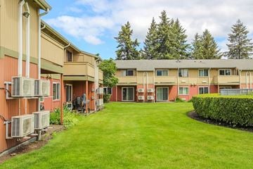 Puyallup apartment for rent - A grassy courtyard is surrounded by apartment buildings.