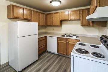 Lakewood apartment for rent - A white refrigerator is in a kitchen with wooden cabinets.