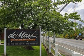 Tacoma apartment for rent - A sign for deMark Apartments is displayed by the roadside.