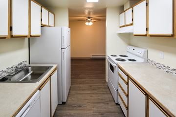 Tacoma apartment for rent - A kitchen with white appliances and wooden cabinets.