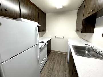 Tacoma apartment for rent - A white refrigerator is in a kitchen with wood cabinets.