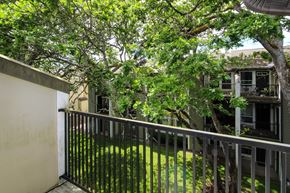 Puyallup apartment for rent - A balcony with a metal railing and a tree in the background.