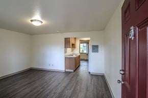 Lakewood apartment for rent - A room with a red door and a kitchen area in the background.