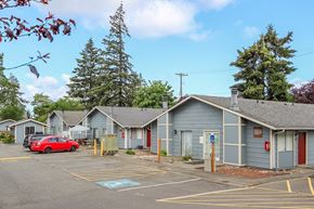 Lakewood apartment for rent - A parking lot with a red car and a building with the number 1084 on it.