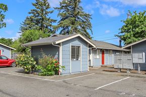 Lakewood apartment for rent - A small blue house with a red car parked in front.