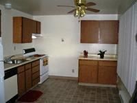 Lakewood apartment for rent - A kitchen with wooden cabinets and a fan.