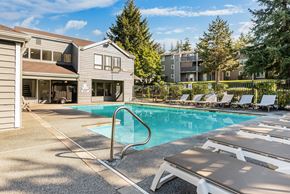 Federal Way apartment for rent - A pool with sun loungers in front of a building.
