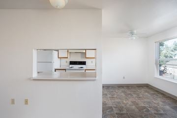 Aloha apartment for rent - A kitchen with a fridge, stove, and oven is visible through a window.