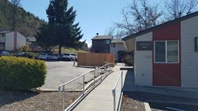 Rogue River apartment for rent - a sidewalk in front of a building with a ramp next to it
