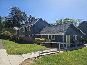 Lincoln City apartment for rent - A blue house with a yellow door and a metal railing.