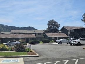 Winston apartment for rent - A parking lot with a building in the background and a car parked in the handicap spot.