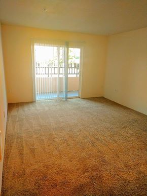Hillsboro apartment for rent - A room with a carpeted floor and a sliding glass door leading to a balcony.