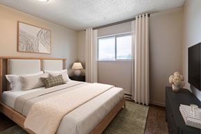 Chehalis apartment for rent - A bedroom with a large bed and a television.