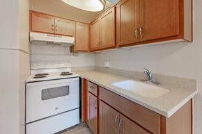 Olympia apartment for rent - A kitchen with a white stove and wooden cabinets.