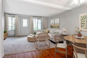 Bremerton apartment for rent - A living room with a white couch, a wooden table, and a rocking chair.