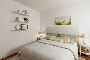 Port Townsend apartment for rent - A white bedroom with a large bed and a painting on the wall.