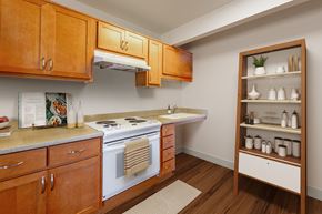 Port Townsend apartment for rent - A kitchen with wooden cabinets and a white stove top oven.