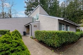 Bremerton apartment for rent - A grey building with a green sign on the front.