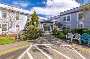 Port Townsend apartment for rent - A sunny day at the entrance of a building with a white and grey facade.