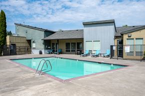Hillsboro apartment for rent - A swimming pool with a diving board in front of a building.