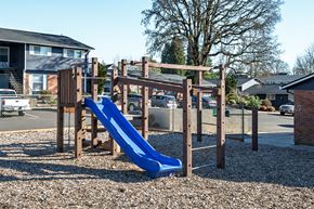 Milwaukie apartment for rent - A playground with a blue slide and wooden structure.