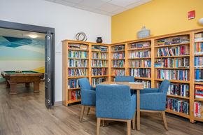 Portland apartment for rent - A room with a pool table and a bookshelf filled with books.
