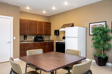 Mcminnville apartment for rent - A kitchen with a table and chairs in the foreground and a refrigerator in the background.