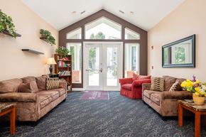 Tualatin apartment for rent - A living room with a couch, chair, and a potted plant.